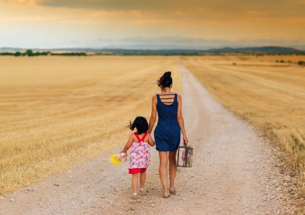 Mother walking her child down a long road